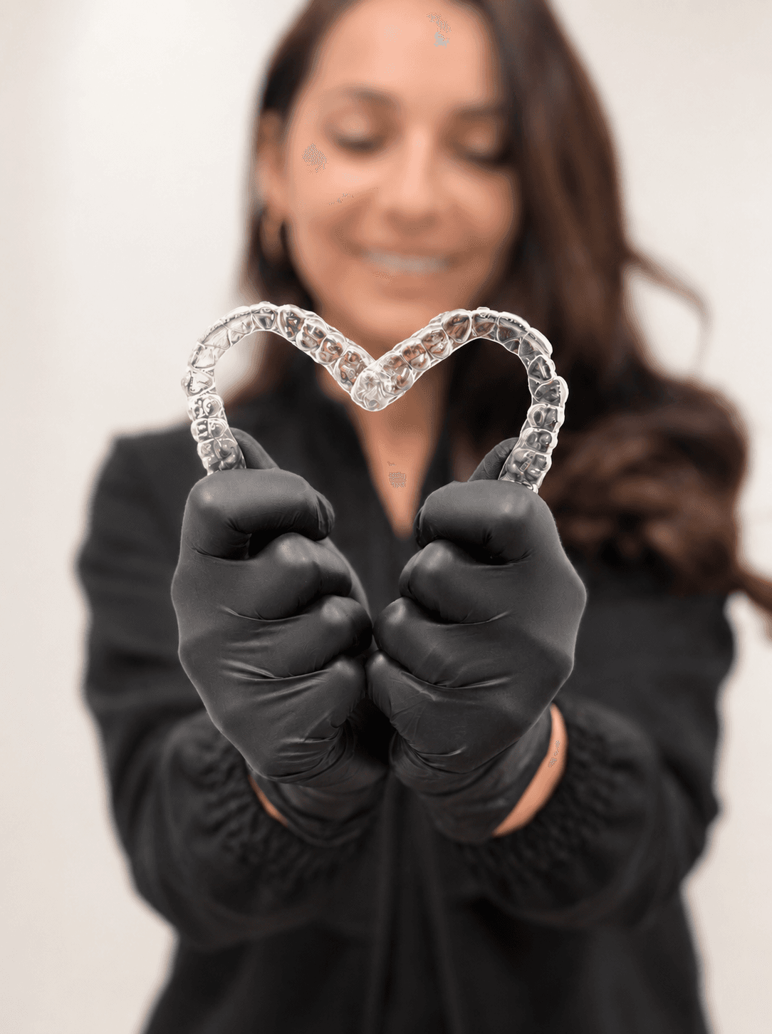 Two clear aligner trays held up in the shape of a heart